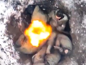 A Ukrainian drone drops a grenade into a Russian foxhole.