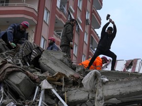 Emergency team members and others search for people in a destroyed building in Adana, Turkey, Monday, Feb. 6, 2023. A powerful earthquake has knocked down multiple buildings in southeast Turkey and Syria and many casualties are feared.
