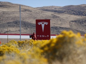 FILE - A sign marks the entrance to the Tesla Gigafactory in Sparks, Nev., on Oct. 13, 2018. Tesla may receive over $300 million in tax abatements over the next two decades for a massive new expansion of its northern Nevada facility, the product of a 2014 deal for when the company first came to the area on the promise of new jobs and major investments in the area.