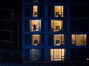 A person stands at the window of a room at a government-authorized COVID-19 quarantine hotel in Richmond, B.C. on February 28, 2021.