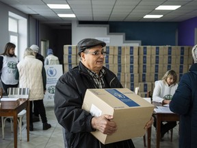 A man receives humanitarian aid provided by UN World Food Program and ADRA charity organisation for the residents of the region and internally displaced persons at the distribution center in Kostiantynivka, Ukraine, Friday, Feb. 10, 2023.