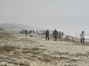 Rescuers arrive at the scene after a migrant boat broke apart in rough seas, at a beach near Cutro, southern Italy, Sunday, Feb. 26, 2023.