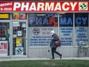 A pedestrian walks past a pharmacy in Parkdale, Toronto. 