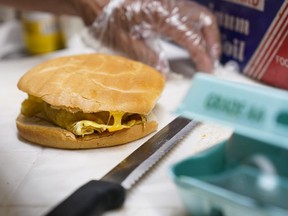 FILE - Hector Perez prepares to wrap a bacon, egg and cheese sandwich at a bodega in the Bronx section of New York, Friday, July 22, 2022. While some travelers cringe at the thought of greasy sausages and bland eggs served at the free hotel breakfast buffet, others say free breakfast ranks among their favorite aspects of travel. Hilton says "free breakfast" is the most used search filter on its website. In 2023, some hotels are revamping their offerings to try to change the minds of even the most skeptical travelers, offering healthier, customizable choices that include DIY yogurt bowls and higher-protein dishes, plus more flexible eating hours.