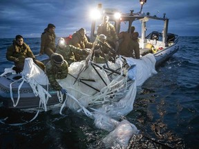 This image provided by the U.S. Navy shows sailors assigned to Explosive Ordnance Disposal Group 2 recovering a high-altitude surveillance balloon off the coast of Myrtle Beach, S.C., Feb. 5, 2023. (U.S. Navy via AP)