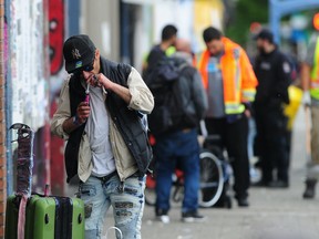 City of Vancouver workers clean the sidewalks in the Downtown Eastside with a police escort in Vancouver, BC., on June 19, 2022. 
(NICK PROCAYLO/PNG)