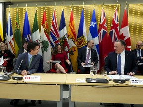 Quebec Premier Francois Legault sits beside Prime Minister Justin Trudeau as Canada's premiers meet in Ottawa on Tuesday, Feb. 7, 2023 in Ottawa. Minister of Finance Chrystia Freeland and Minister of Health Jean-Yves Duclos sit behind.