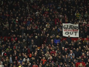 An anti-Glazer family banner is held up by members of the crowd before the English League Cup semifinal second leg soccer match between Manchester United and Nottingham Forest at Old Trafford in Manchester, England, Wednesday, Feb. 1, 2023. The Glazer family are the owners of Manchester United.