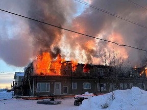 A fire is seen at an apartment on Tataskweyak Cree Nation in northern Manitoba on Saturday, Feb.11, 2023. A 17-year-old girl and a toddler are in critical condition in hospital after police say the teen rescued children from a burning home on a northern Manitoba First Nation.