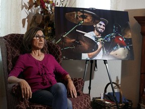 Dolores Cruz pose à côté d'une photo de son fils, Eric Cruz, le mercredi 1er février 2023, chez elle à San Gabriel, en Californie.
