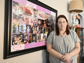 Jessica Day-Weaver poses next to a picture collage made for her daughter, Anastasia, at her home, Thursday, Feb. 2, 2022, in Boardman, Ohio.