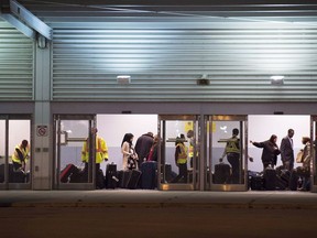 Yet another global conference in Montreal risks being derailed by Canada's delays in processing visas and rejections that critics argue punish those from poorer countries. Workers help newly arrived refugees load their luggage onto busses at Pearson International airport, in Toronto, on Friday, Dec. 11, 2015.