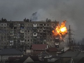 An explosion erupts from an apartment building at 110 Mytropolytska St., after a Russian army tank fired on it in Mariupol, Ukraine, Friday, March 11, 2022. On the seventh floor of the building, two elderly women Lydya and Nataliya were stuck in their apartment because they couldn't make it down to the shelter, and were killed in the explosion. The two heavily burned bodies were buried by neighbors in front of the building.