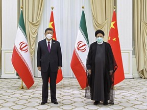 FILE - In this file photo released by China's Xinhua News Agency, Iran's President Ebrahim Raisi, right, and Chinese President Xi Jinping pose for a photo on the sidelines of a meeting at the Shanghai Cooperation Organization (SCO) summit in Samarkand, Uzbekistan on Sept. 16, 2022. Ebrahim Raisi will visit China for a three-day trip on Tuesday, Feb. 14, 2023, at the invitation of Chinese President Xi.