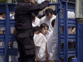 File - Men who were detained under a state of exception, are transported in a livestock trailer to a detention center in Soyapango, El Salvador, on Oct. 7, 2022. The government of President Nayib Bukele asked on Tuesday, Feb. 14, 2023, for a new extension on the ongoing state of exception that suspends the country´s constitutional rights, as he continues his fights against gangs.