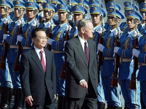 Visiting Canadian Prime Minister Jean Chretien (R) walks beside Chinese Premier Wen Jiabao, 22 October 2003, during a review of the honour guard at a welcoming ceremony at the Great Hall of the People in Beijing. Chretien and his delegation arrived late 21 October for an official four-day visit to China. AFP PHOTO/Frederic J. BROWN