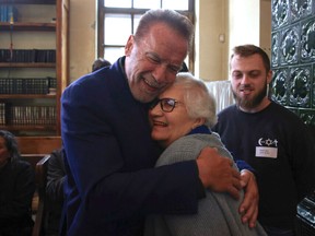 Arnold Schwarzenegger, left, hugs Holocaust survivor Lydia Maksimovicz, right, in Oswiecim, Poland, Wednesday, Sept. 28, 2022.