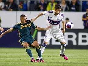 LA Galaxy forward Dejan Joveljic, left, defends against Vancouver Whitecaps defender Ranko Veselinovic during the first half of an MLS soccer match in Carson, Calif., Saturday, March 18, 2023.