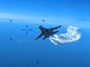SEVASTOPOL, UKRAINE - MARCH 14: In this screengrab of a video clip released by the United States Defense Department's European Command, a Russian Su-27 fighter jet flies near an American MQ-9 Reaper drone, spraying what the US government says is jet fuel, on March 14, 2023 over the Black Sea near Crimea.