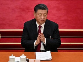 China's President Xi Jinping applauds during the opening session of the National People's Congress (NPC) at the Great Hall of the People in Beijing on March 5, 2023. (Photo by NOEL CELIS / AFP)