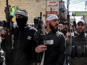 Palestinian gunmen march during the March 8 funeral of Abdel Fatah Hussein Khroushah, a 49-year-old Palestinian who was killed after murdering two Israeli settlers in the Palestinian town of Huwara.