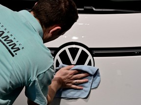 A worker polishes the logo of German car giant Volkswagen on March 14, 2023 in Berlin.