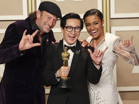 Best Supporting Actor Oscar winner Ke Huy Quan poses with presenters Troy Kotsur (left) and Ariana DeBose.
