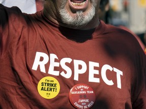A protester is wearing a red shirt with "Respect" printed on it at the CRA Strike.