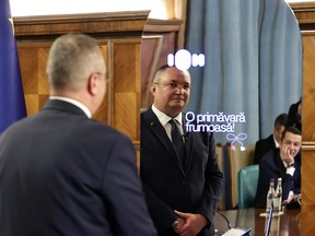 Romanian Prime Minister Nicolae Ciuca interacts with "Ion," an AI-powered government aide. Some Romanians are concerned that Ion's algorithm, which identifies which concerns on social media should be prioritized for decision-making, could itself be biased - resulting in biased decision-making.