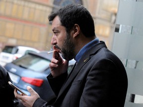 Italian politician Matteo Salvini smokes a cigarette during an electoral rally in Palermo, Italy in 2018. Italy's health minister is proposing a ban on outdoor smoking at bars, transportation stops and parks.