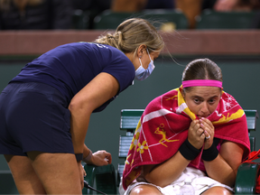 Jelena Ostapenko of Latvia reacts as she receives medical attention in her loss to Petra Kvitova of The Czech Republic during the BNP Parisbas at the Indian Wells Tennis Garden on March 12, 2023 in Indian Wells, California.