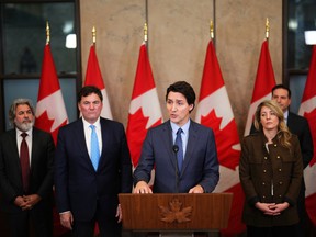 Prime Minister Justin Trudeau, accompanied by cabinet ministers, speaks during a news conference regarding election interference, in Ottawa on Monday, March 6, 2023.