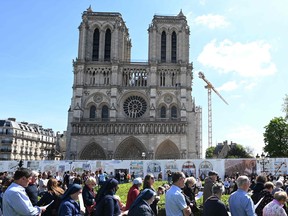 Catholic faithfuls attend a prayer gathering on the square in front of the Notre-Dame cathedral in Paris on April 15, 2022, to mark the third anniversary of a fire that partially destroyed the cathedral.