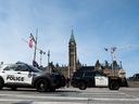 Toronto Police Service and Ontario Provincial Police vehicles are seen on Wellington Street in preparation of U.S. President Joe Biden's visit to Ottawa, March 22, 2023.