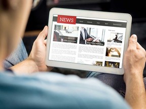 A man reads news on a tablet.