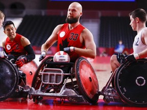 Zak Madell of Team Canada fights with Team Great Britain for the ball during their Group B wheelchair rugby match three on day 1 of the Tokyo 2020 Paralympic Games at Yoyogi National Stadium on Aug. 25, 2021 in Tokyo, Japan.