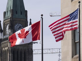 Canadian and United States flags are seen flying near Parliament Hill, Wednesday, March 22.