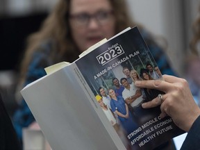 A reporter reads a copy of the Federal Budget in the lockup for the Federal budget, Tuesday, March 28, 2023 in Ottawa.