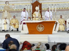 FILE - Pope Benedict XVI, center, celebrates a Mass in front of the Basilica of the Rosary in Lourdes, southwestern France, on Sept. 15, 2008. Behind him is one of the mosaics by Rev. Marko Ivan Rupnik, who was declared excommunicated in 2020 for committing one of the worst crimes in church law – using the confessional to absolve a woman with whom he had engaged in sexual activity. Officials at the Catholic shrine in Lourdes, France announced the creation of a study group Friday, March 31, 2023, to decide what to do with the sanctuary's mosaics, its most famous but now controversial attraction.