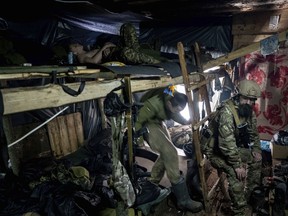 Ukrainian paratroopers of 80 Air Assault brigade rest inside a dugout at the frontline near Bakhmut, Ukraine, Friday, March 10, 2023.
