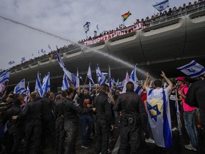Israeli police use water cannon to disperse Israelis protest against plans by Prime Minister Benjamin Netanyahu's government to overhaul the judicial system in Tel Aviv, Israel, Thursday, March 23, 2023.
