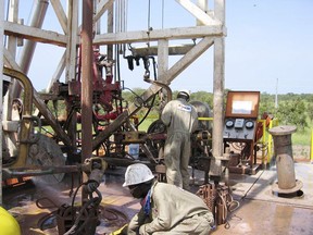 FILE --Chadian workers guide a pipe down a well in the Doba oil fields in southern Chad Oct. 10, 2003. Chad is nationalizing all assets from oil giant Exon Mobil, including hydrocarbon and exploration permits, said Haliki Choua Mahamat the government's general secretary on state media Thursday March 23, 2023.