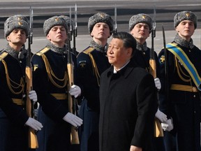 Chinese President Xi Jinping, accompanied by Russian Deputy Prime Minister Dmitry Chernyshenko, walks past honour guards and members of a military band during a welcoming ceremony upon his arrival at an airport in Moscow, Russia, March 20, 2023.