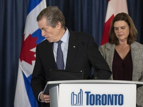 John Tory walks away from the Toronto city hall podium, as deputy mayor Jennifer McKelvie looks on, Friday February 17, 2023.