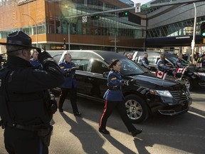 A sheriff salutes during a procession for Edmonton Police Service Const. Travis Jordan and Const. Brett Ryan in Edmonton on Monday, March 27, 2023. The officers were killed in the line of duty on March 16, 2023.