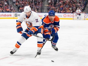 New York Islanders' Zach Parise (11) and Edmonton Oilers' Evan Bouchard (2) battle for the puck during first period NHL action in Edmonton on Thursday January 5, 2023.THE CANADIAN PRESS/Jason Franson
