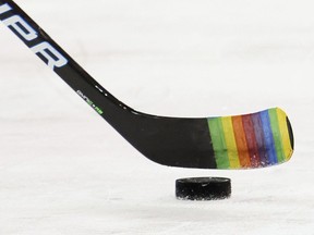 Zac Jones of the New York Rangers skates with a stick decorated for "Pride Night" in warm-ups prior to the game against the Washington Capitals, in New York City, Monday, May 3, 2021.NHL players refusing to participate in Pride nights around the league shows hockey still isn't safe for a number of LGBTQ people, says one of the first male professional players to publicly come out as gay.
