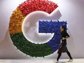 A woman walks past the logo for Google at the China International Import Expo in Shanghai, on Nov. 5, 2018.
