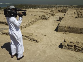 A journalist films uncovered ruins on Siniyah Island in Umm al-Quwain, United Arab Emirates.