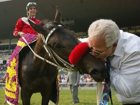 Jockey Steven Bahen sits aboard TJ's Lucky Moon as trainer Vito Armata gives him a kiss after winning the 143rd Queen's Plate at Woodbine Racetrack in Toronto on Sunday June 23, 2002. Bahen, who rode 82-1 longshot T J's Lucky Moon to a stunning victory in the 2002 Queen's Plate, retired Monday.